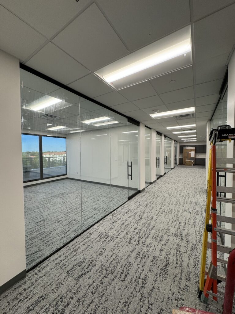 Commercial office corridor with frameless glass walls and doors