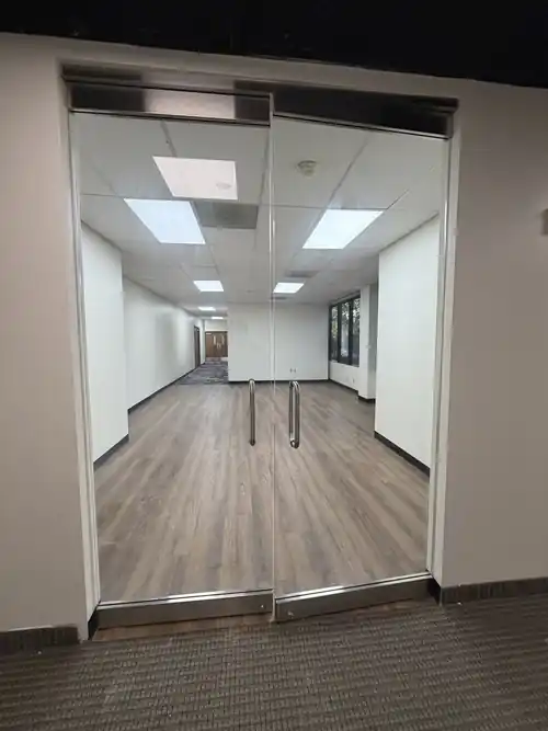 Frameless double glass doors installed in a commercial office interior